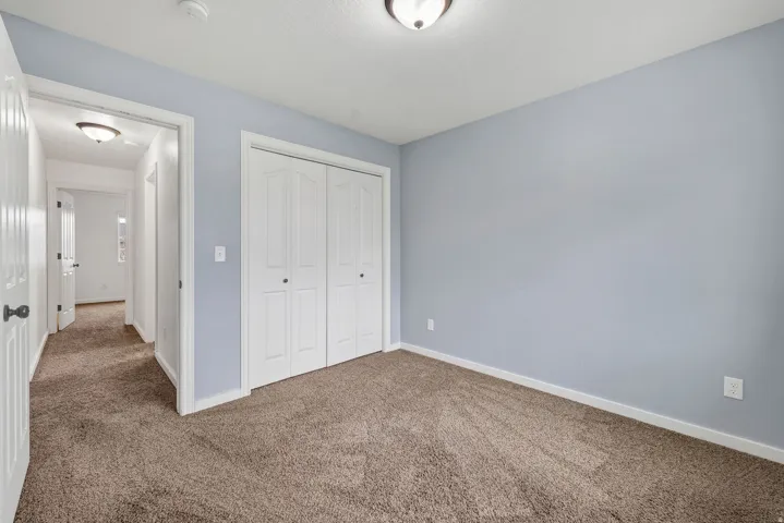 Carpeted room with light blue wall paint, white trim, and a ceiling-mounted light fixture