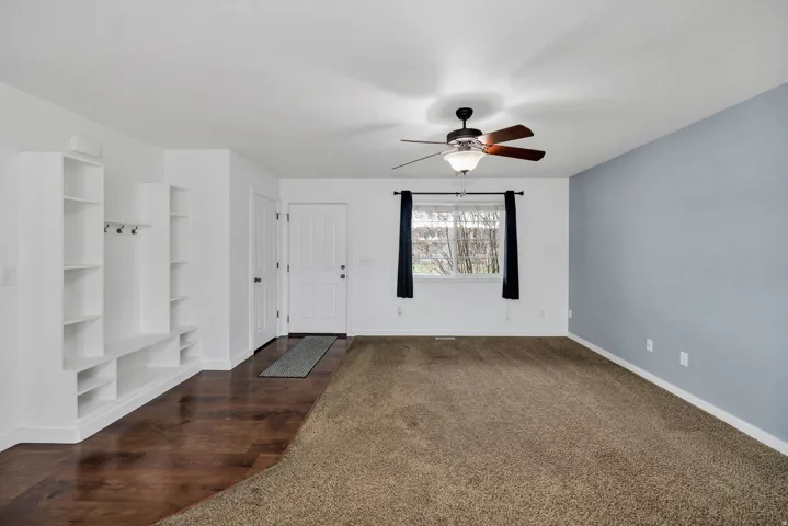 Entryway featuring built-in shelving, wood-finish flooring, and a ceiling fan with integrated lighting