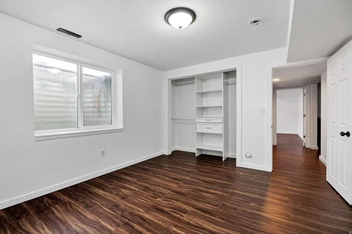 Bright room featuring rich wood-finish flooring and a neutral color palette