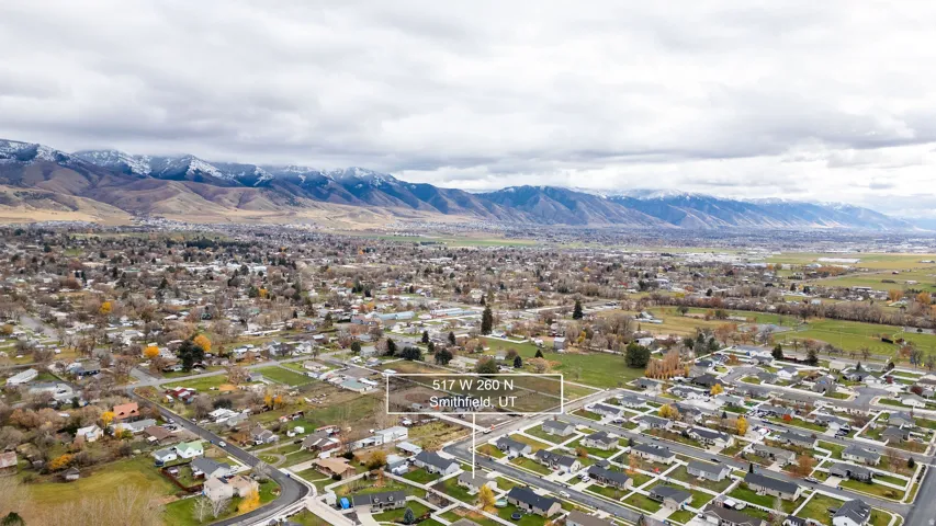 Expansive aerial showing a residential area with a prominent mountain range backdrop