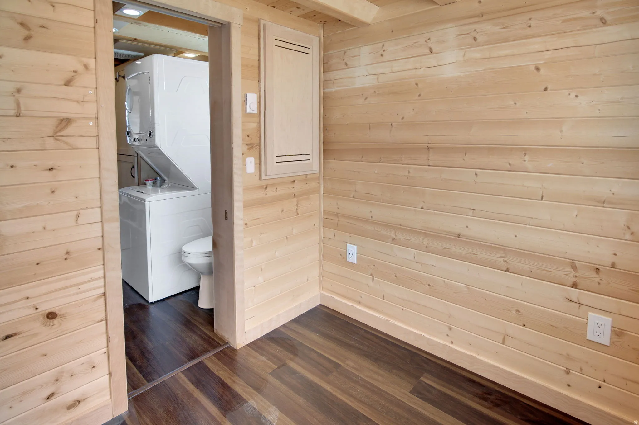 Light-toned wood plank walls complement the rich wood-finish flooring
