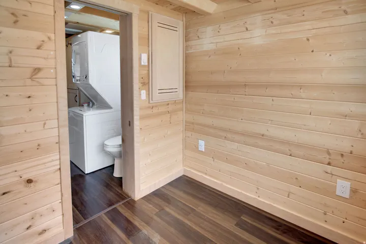Light-toned wood plank walls complement the rich wood-finish flooring