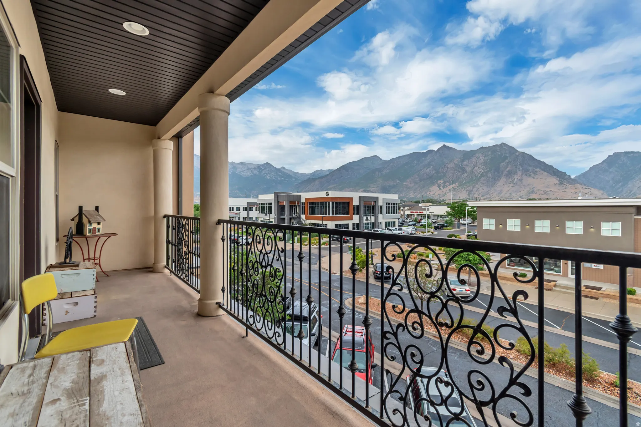 Private balcony featuring a decorative wrought iron railing, columns, recessed lighting, and a durable flooring surface