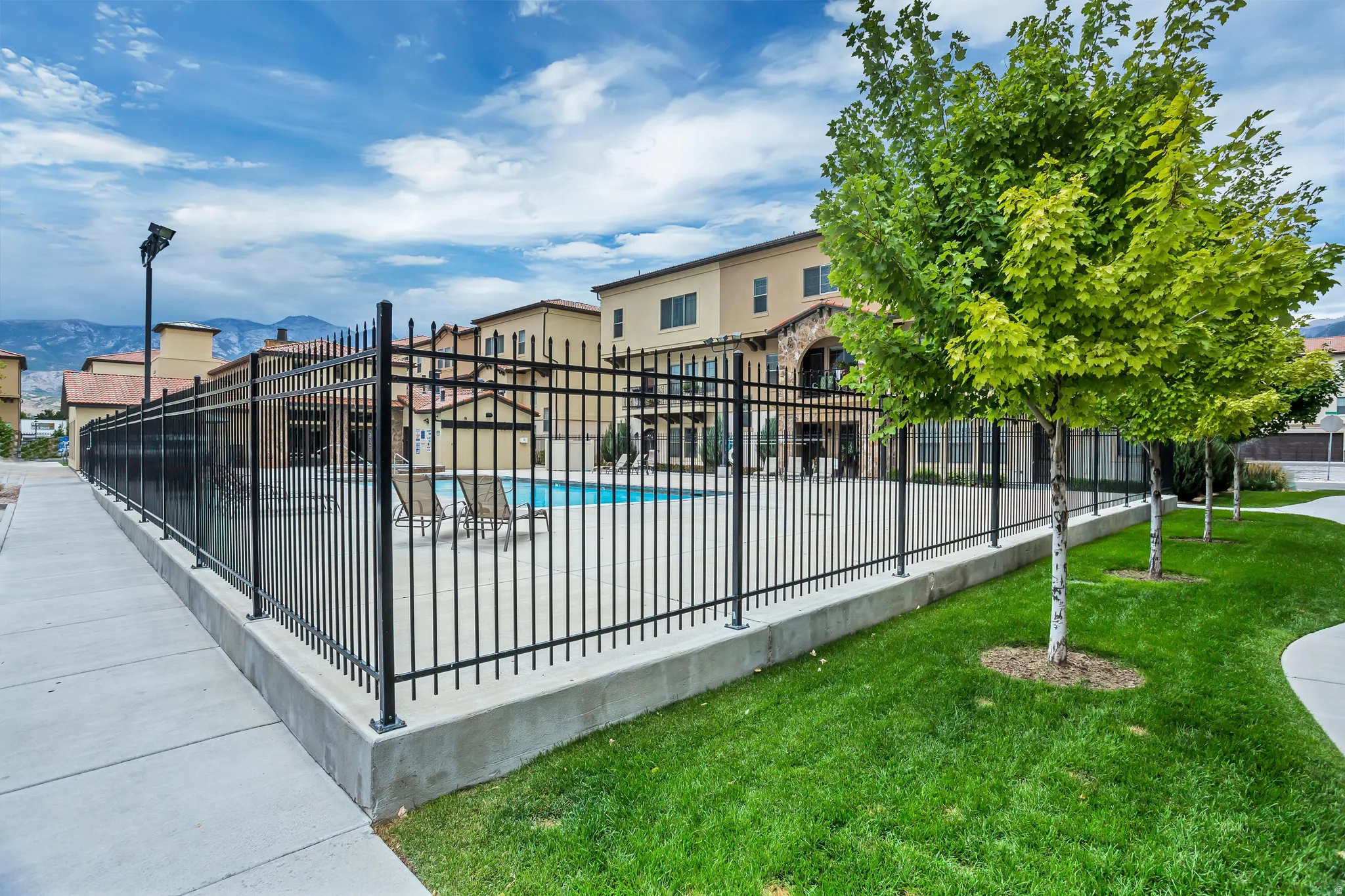 Community swimming pool with black wrought iron fencing