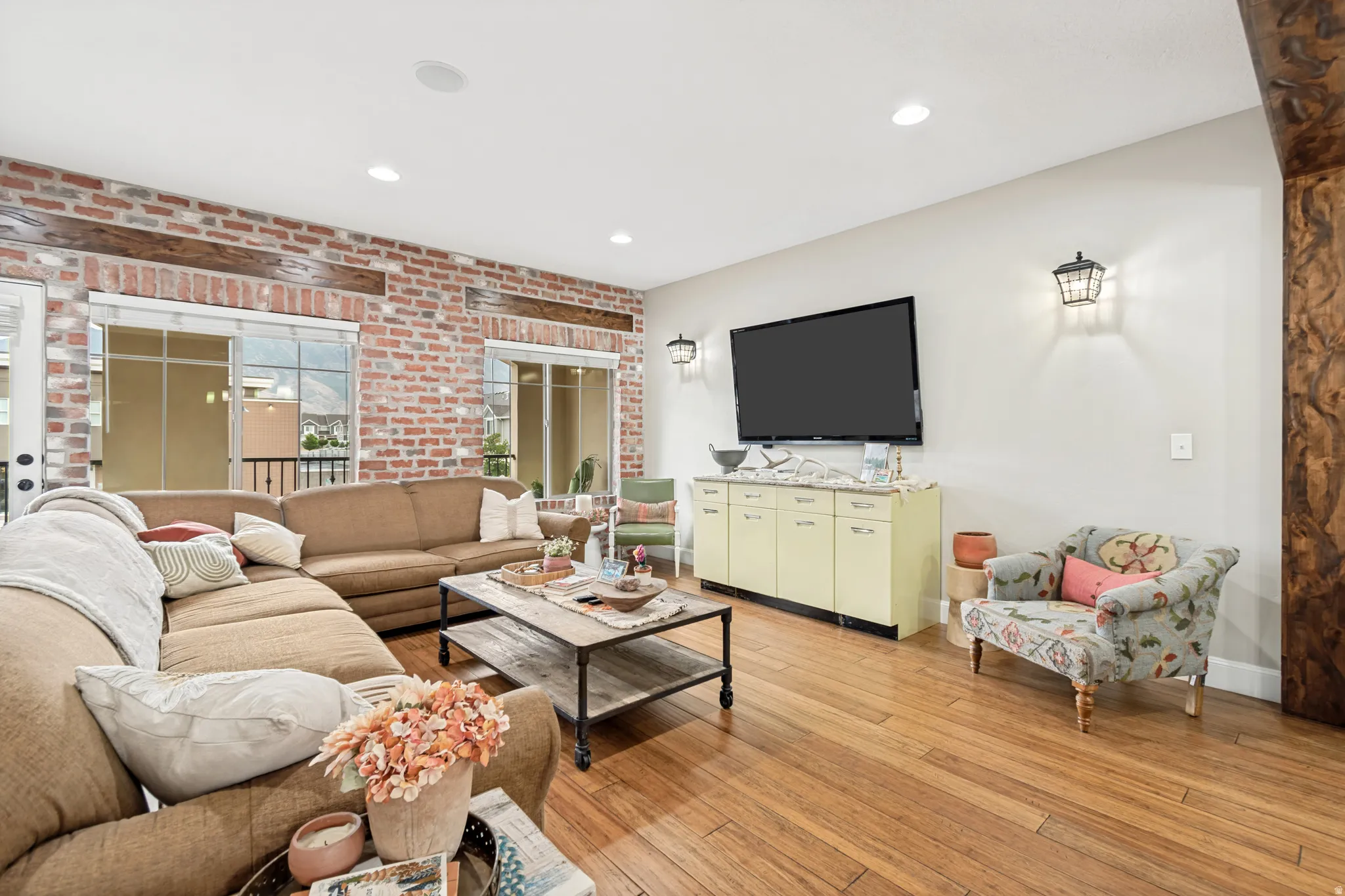 Spacious living area featuring exposed brick accents and wood beams