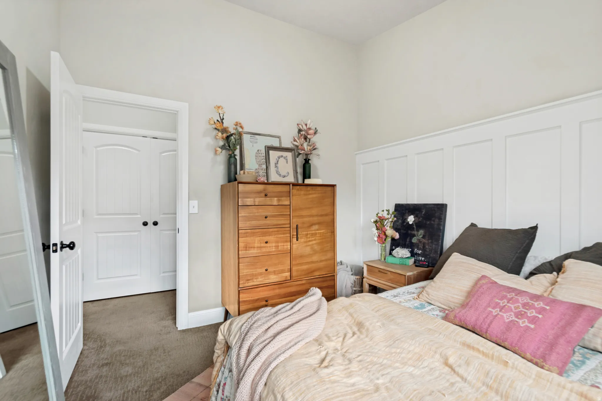 Bedroom featuring white board and batten wall paneling, light-toned wall paint, and gray carpet flooring
