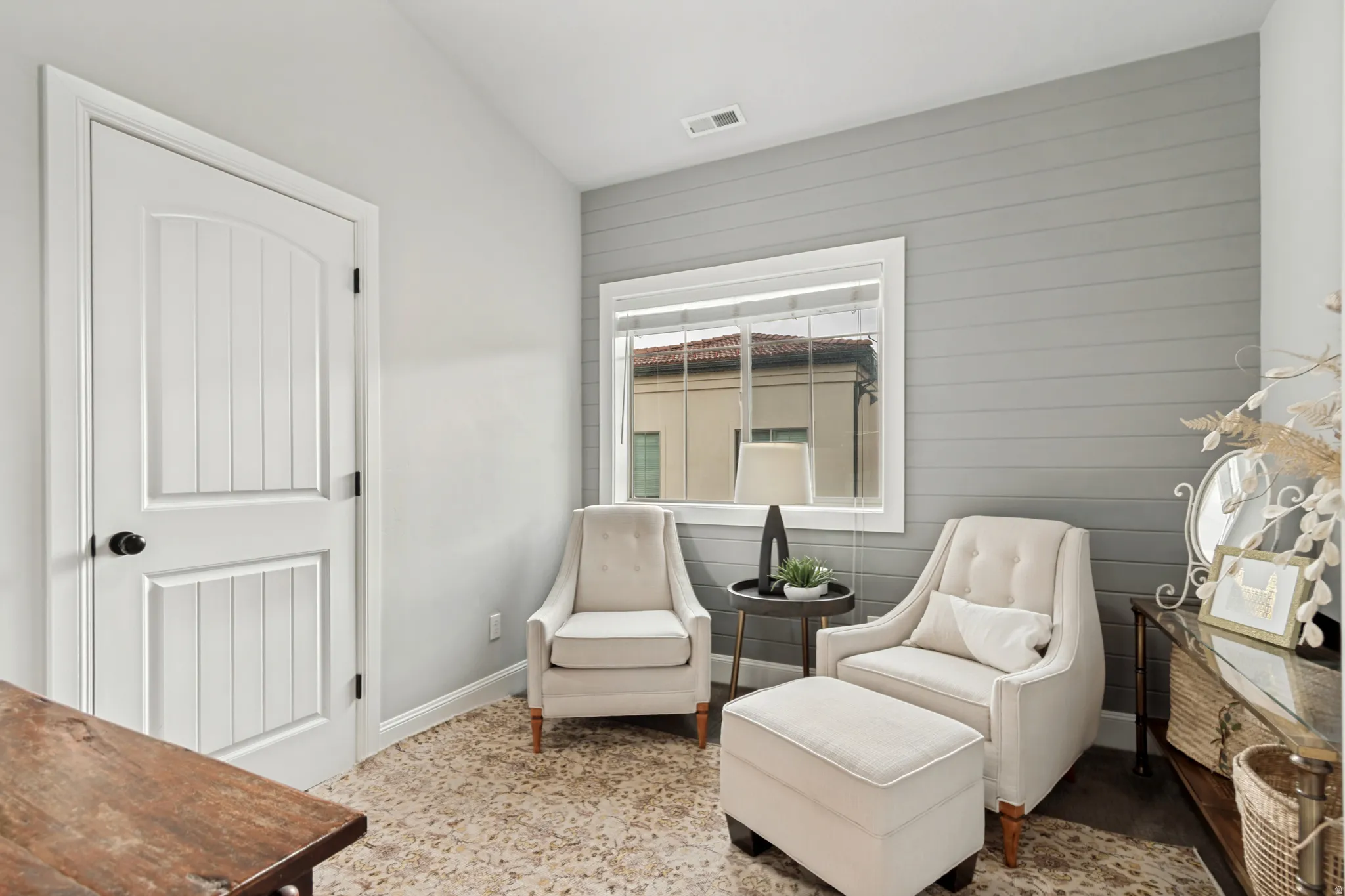 Accent wall featuring horizontal paneling and a large window with blinds