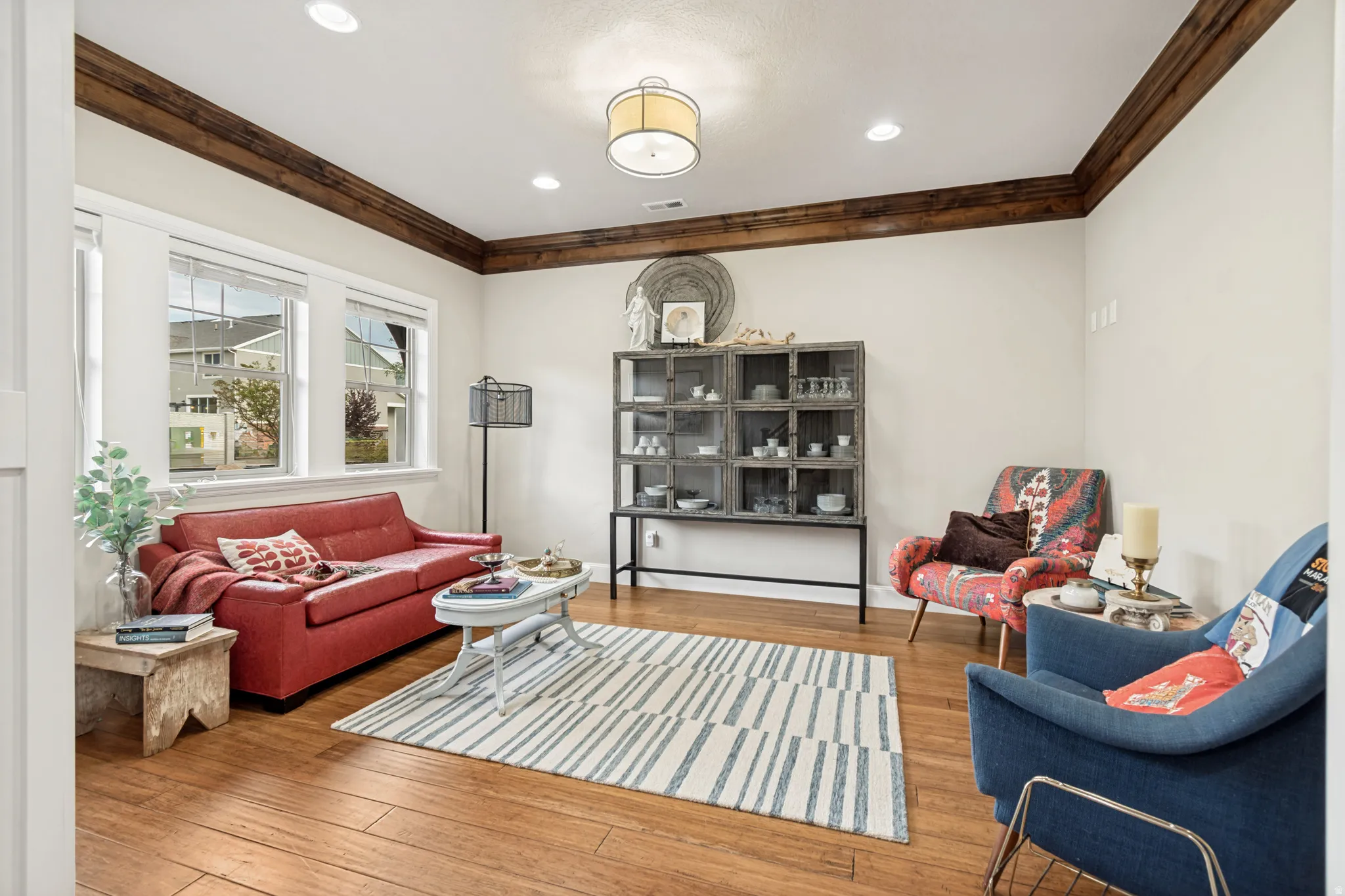 Living area featuring wood-finish flooring, recessed lighting, and crown molding