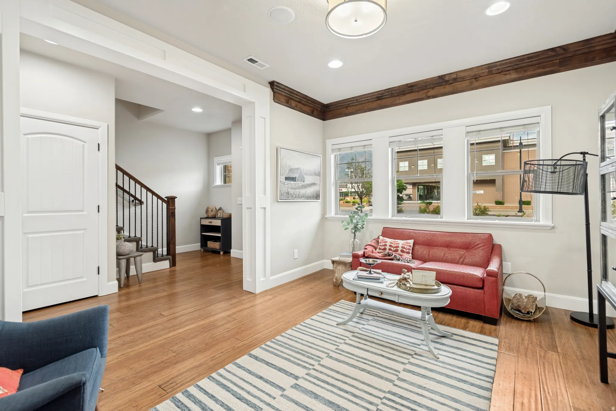 Living area featuring wood-finish flooring and three large windows