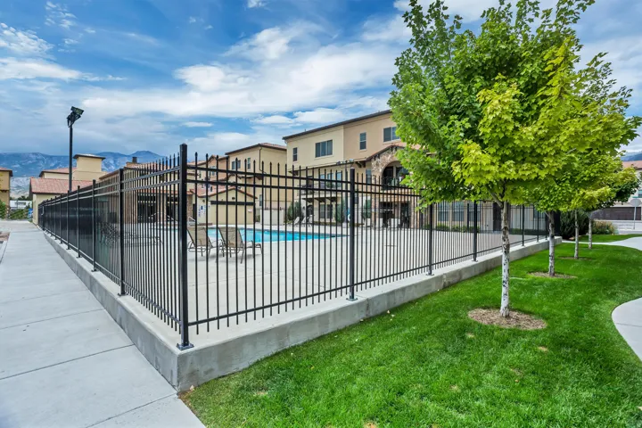 Community swimming pool with black wrought iron fencing
