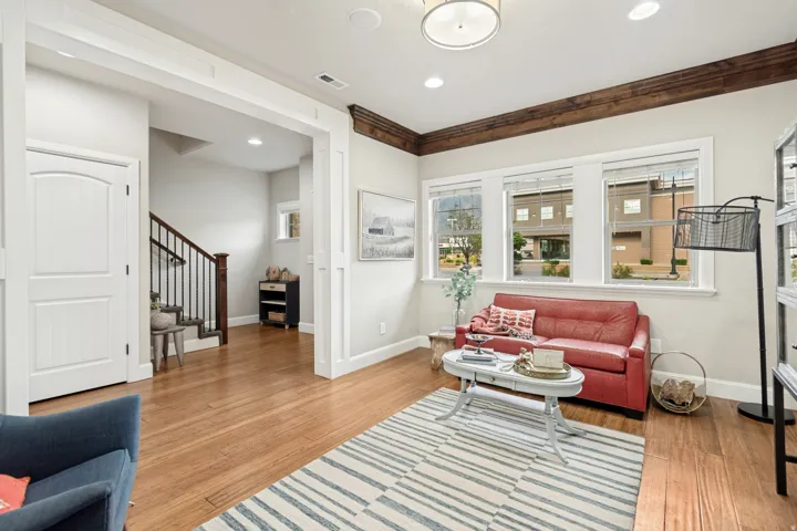 Living area featuring wood-finish flooring and three large windows