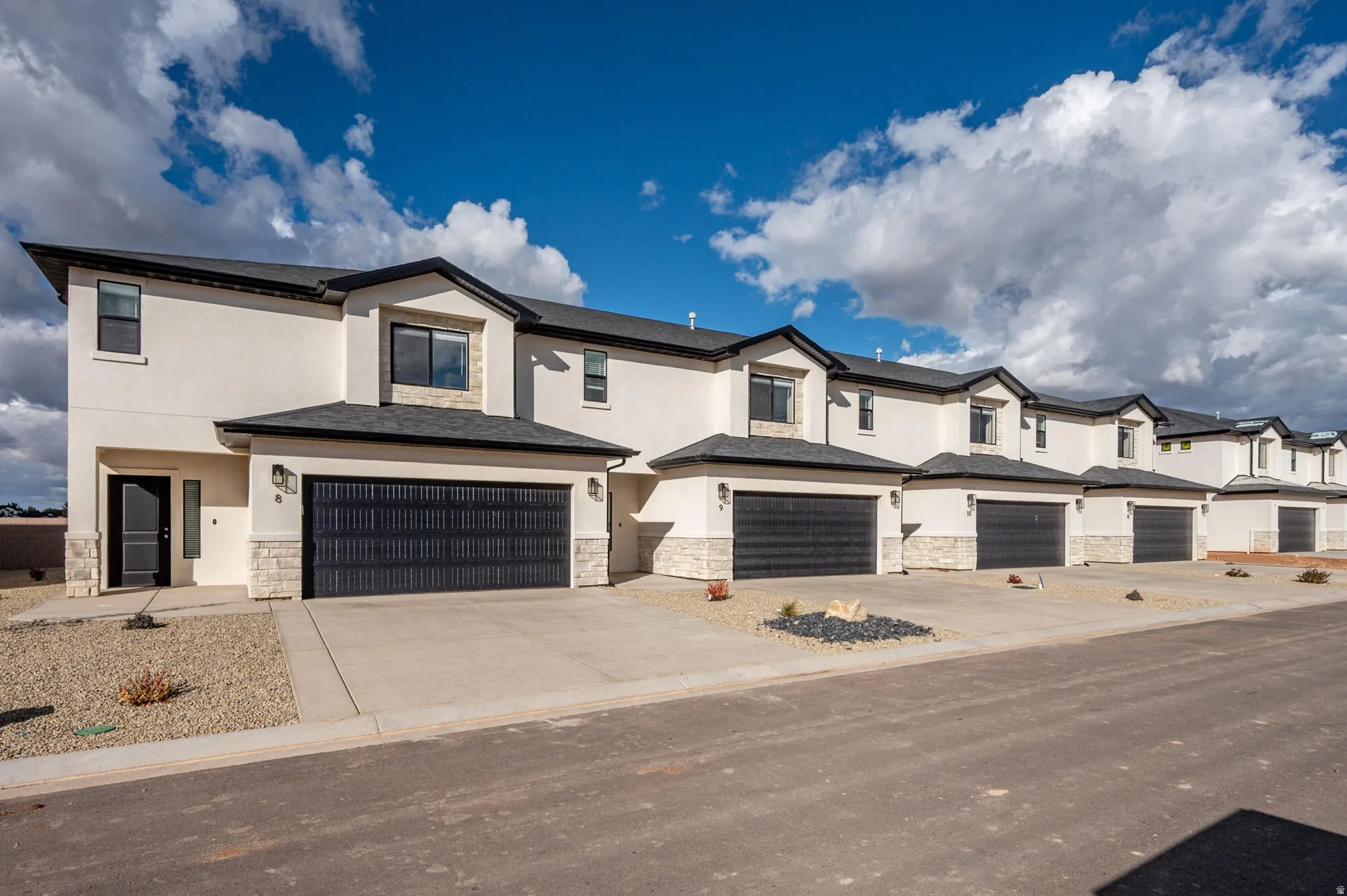 Contemporary townhome exteriors featuring stucco and stone veneer accents