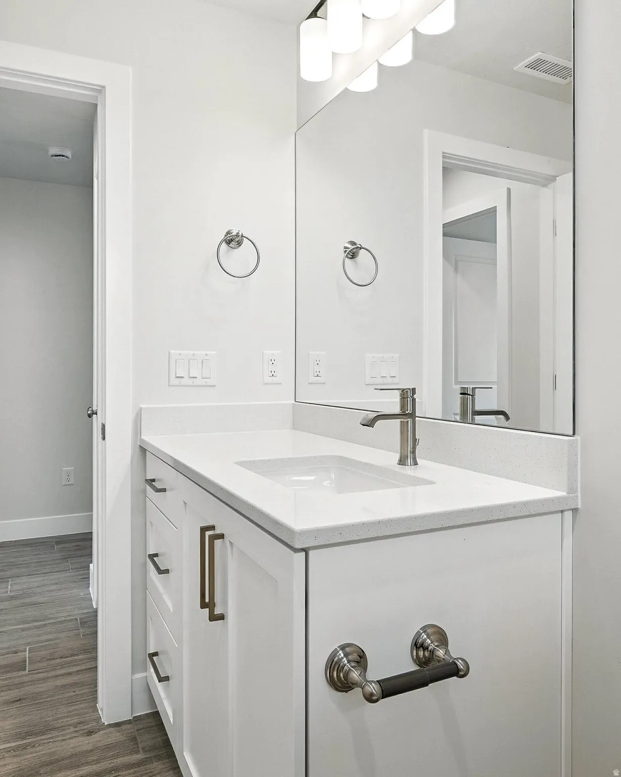 Bathroom vanity featuring white cabinetry, a light-toned countertop, and an undermount sink