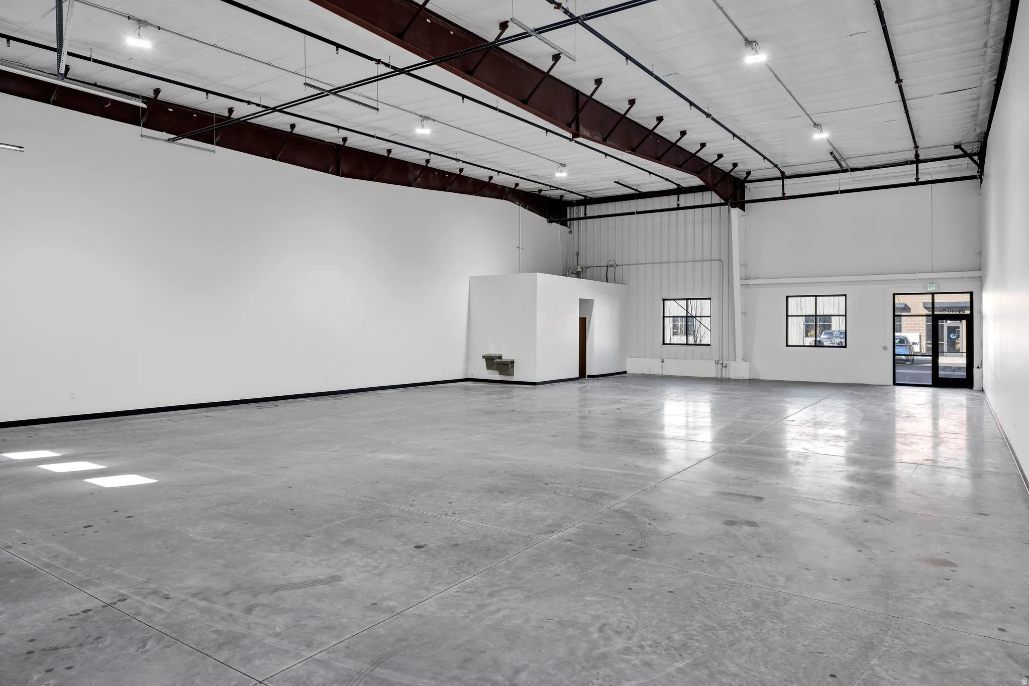 Expansive concrete flooring with high ceilings and exposed metal beams