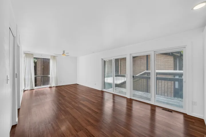 Spacious main living area featuring wood-finish flooring and white walls