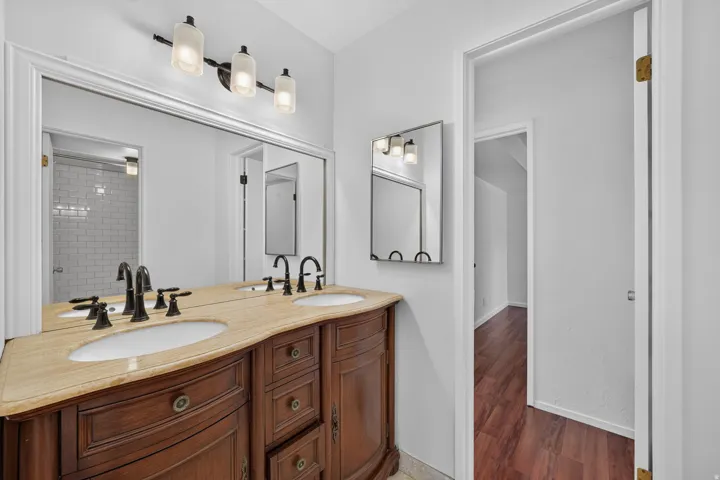 Bathroom featuring a double vanity with a light-toned countertop, dual undermount sinks, and dark bronze fixtures