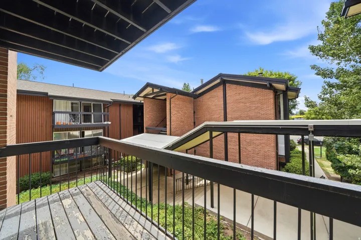 Exterior balcony featuring black railing and wood-finish flooring