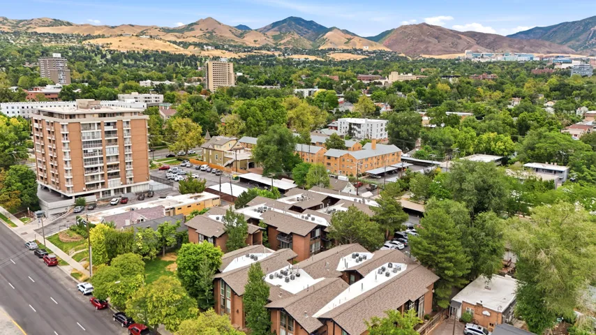 Residential properties featuring pitched shingle roofs and brick facades, surrounded by mature trees