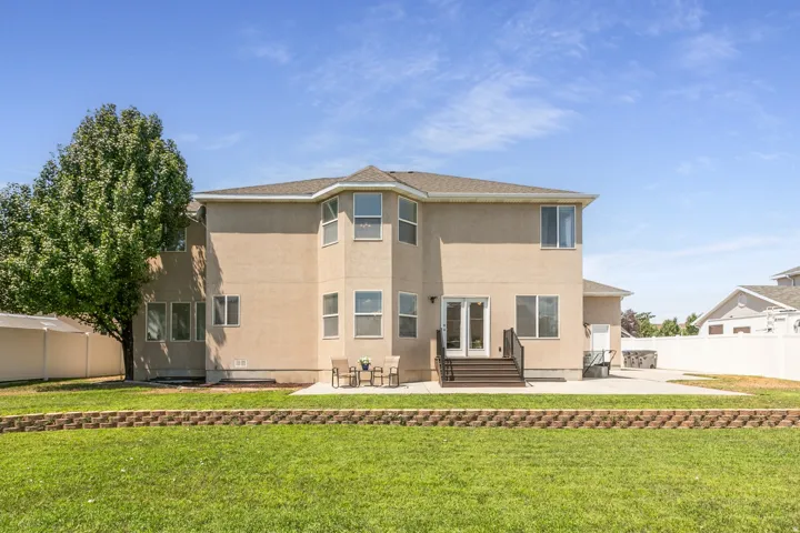 Rear exterior featuring a stucco finish and multiple windows