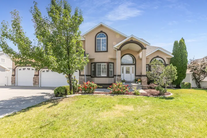 Spacious two-story residence featuring a stucco exterior with stone accents and a three-car garage