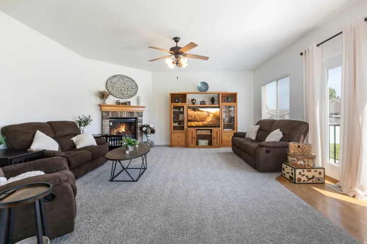 Spacious living area featuring a vaulted ceiling and light-toned carpeting