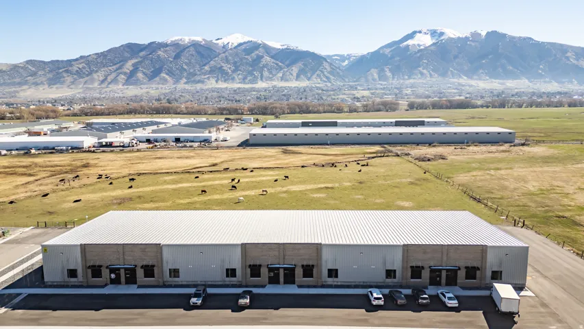 Industrial building with multiple loading docks, a metal roof, and a paved parking lot
