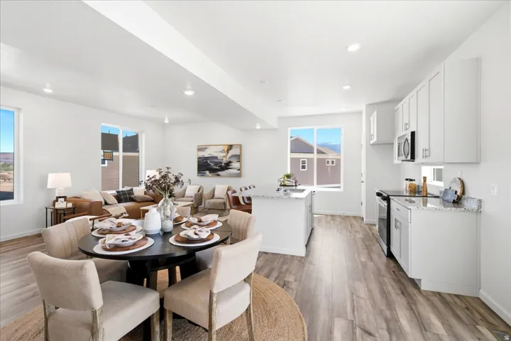 Open-concept living space featuring wood-finish flooring, recessed lighting, and expansive windows
