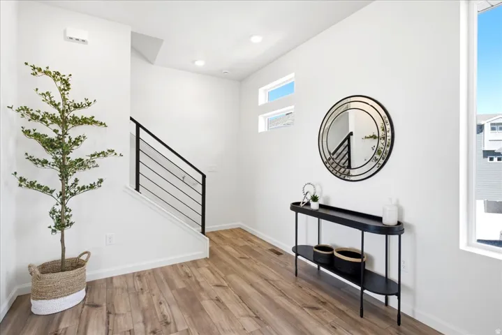 Entryway featuring wood-finish flooring and a modern staircase with black metal railings