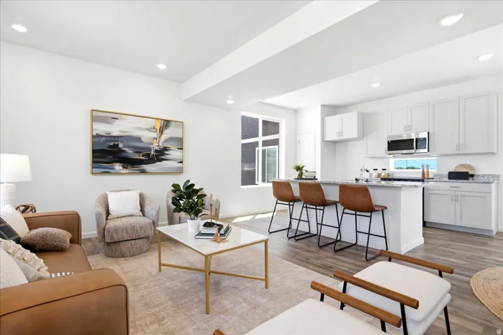 Open-concept living area featuring wood-finish flooring, recessed lighting, and white walls