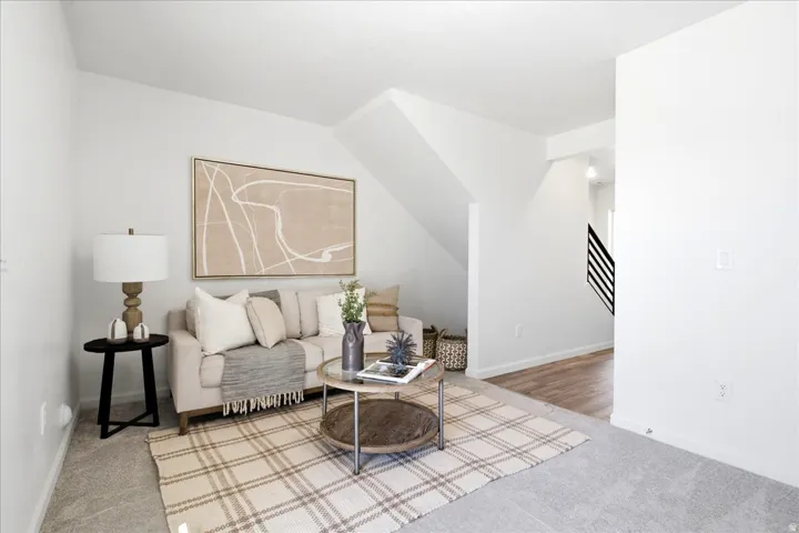 Open-concept living space featuring light gray carpeting and a neutral color palette