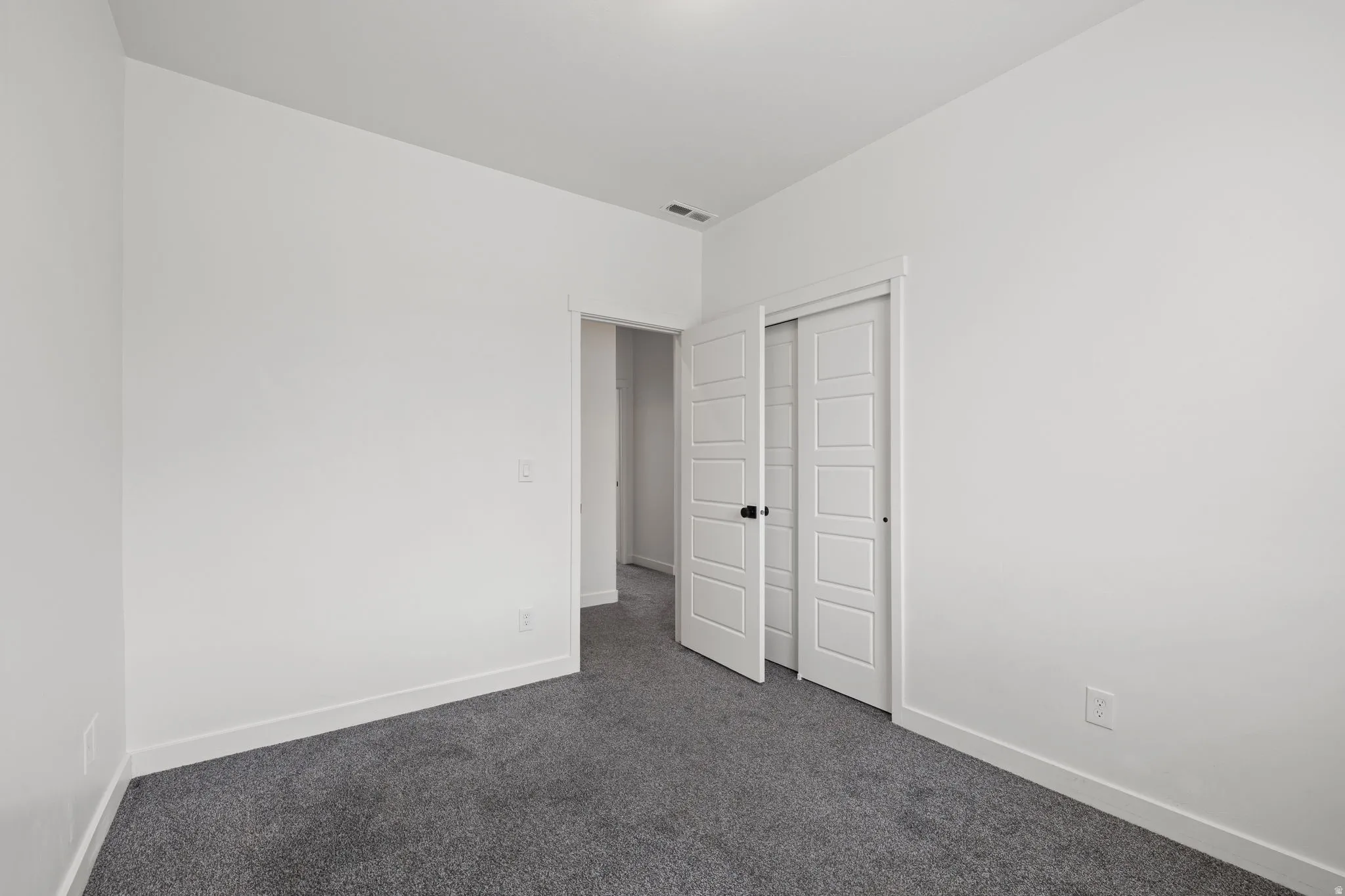 White painted interior with gray carpeting and white baseboards