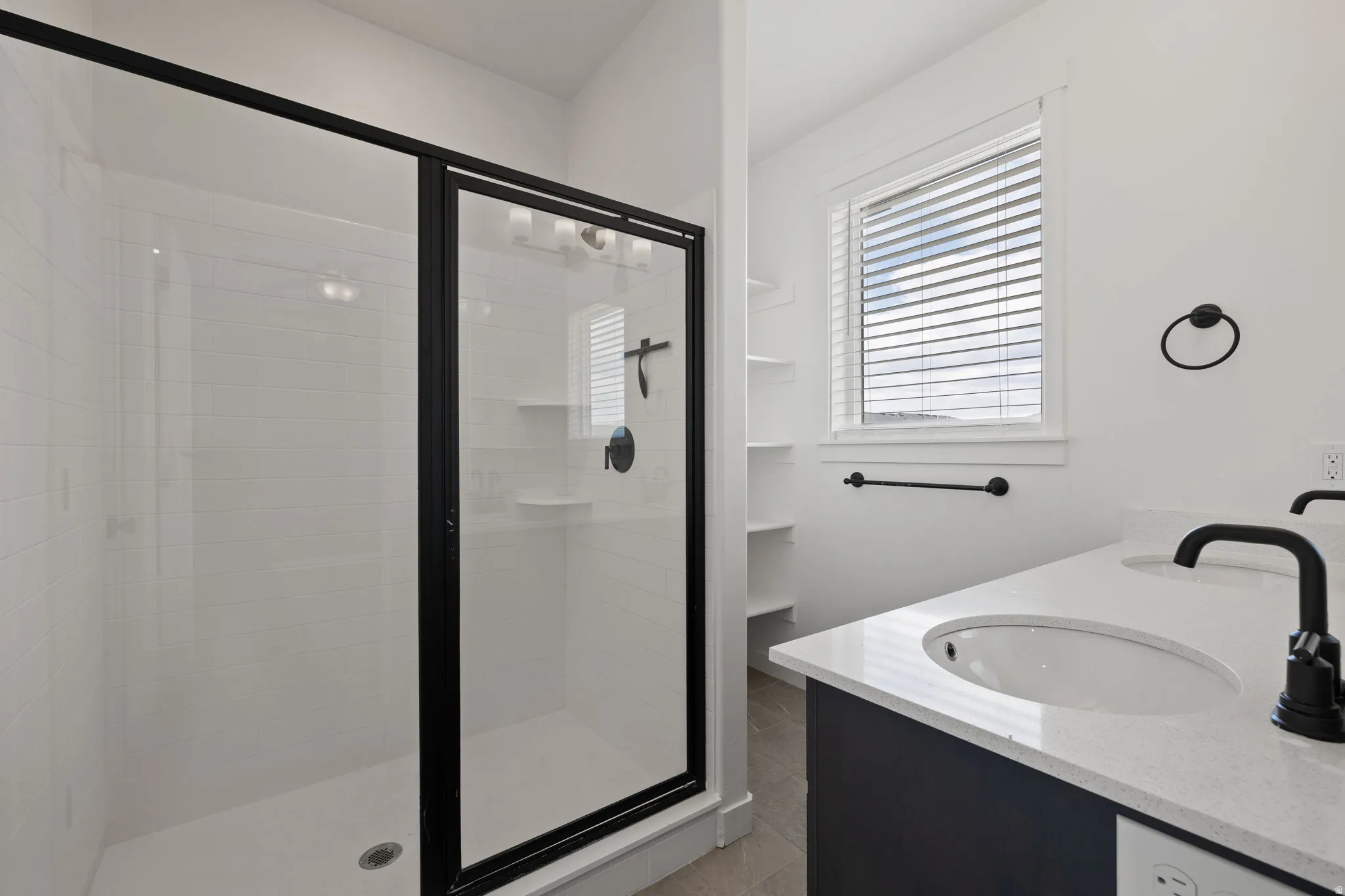 Shower with black-framed glass enclosure and white subway tile surround