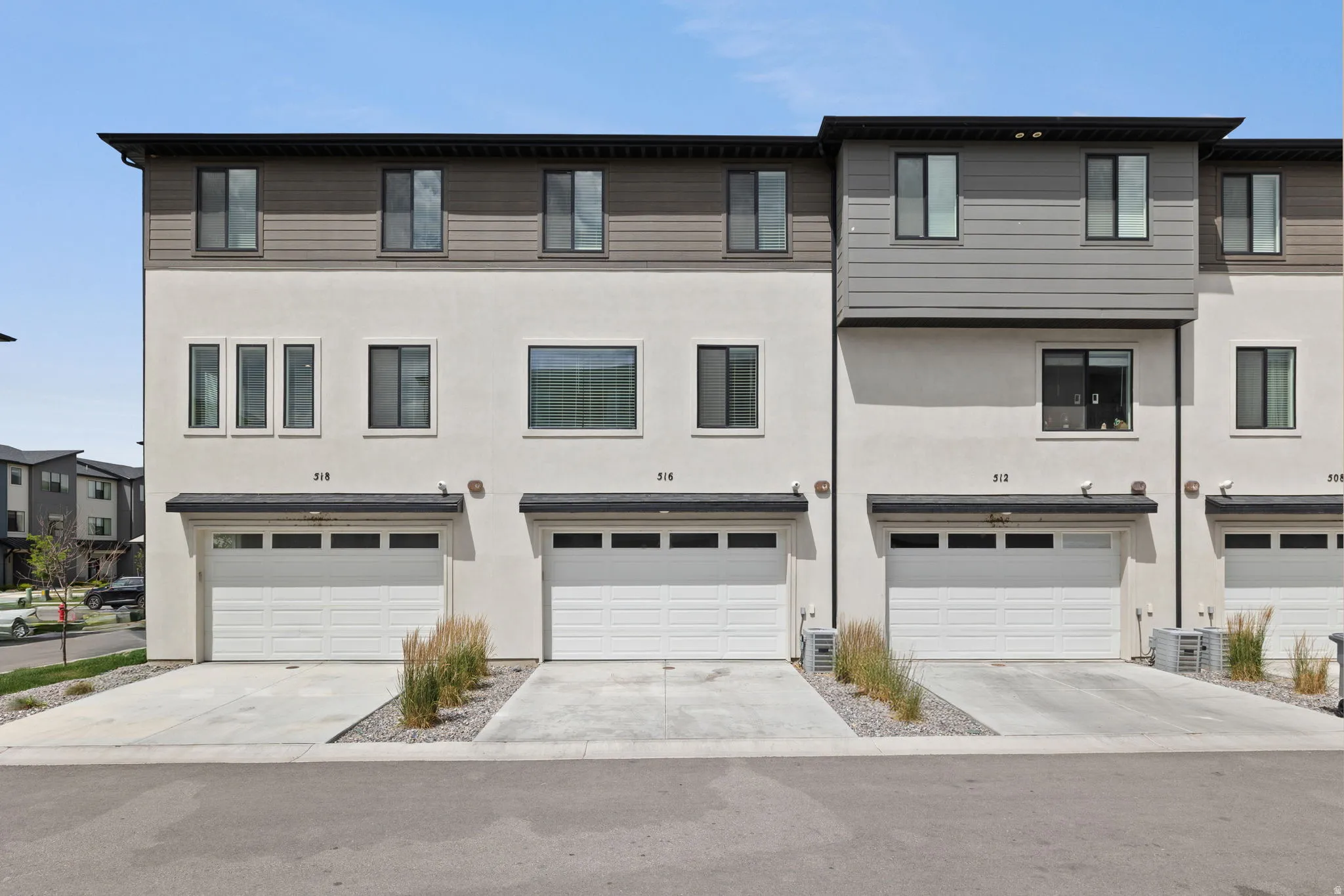 Modern townhome exterior featuring a neutral stucco and horizontal siding facade