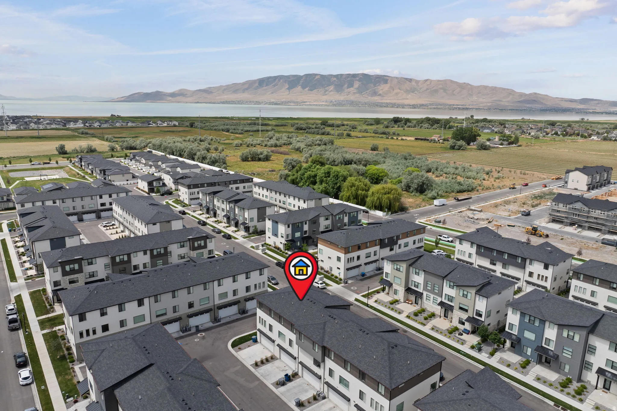 Aerial perspective showcasing a community of multi-story townhomes with dark shingle roofs