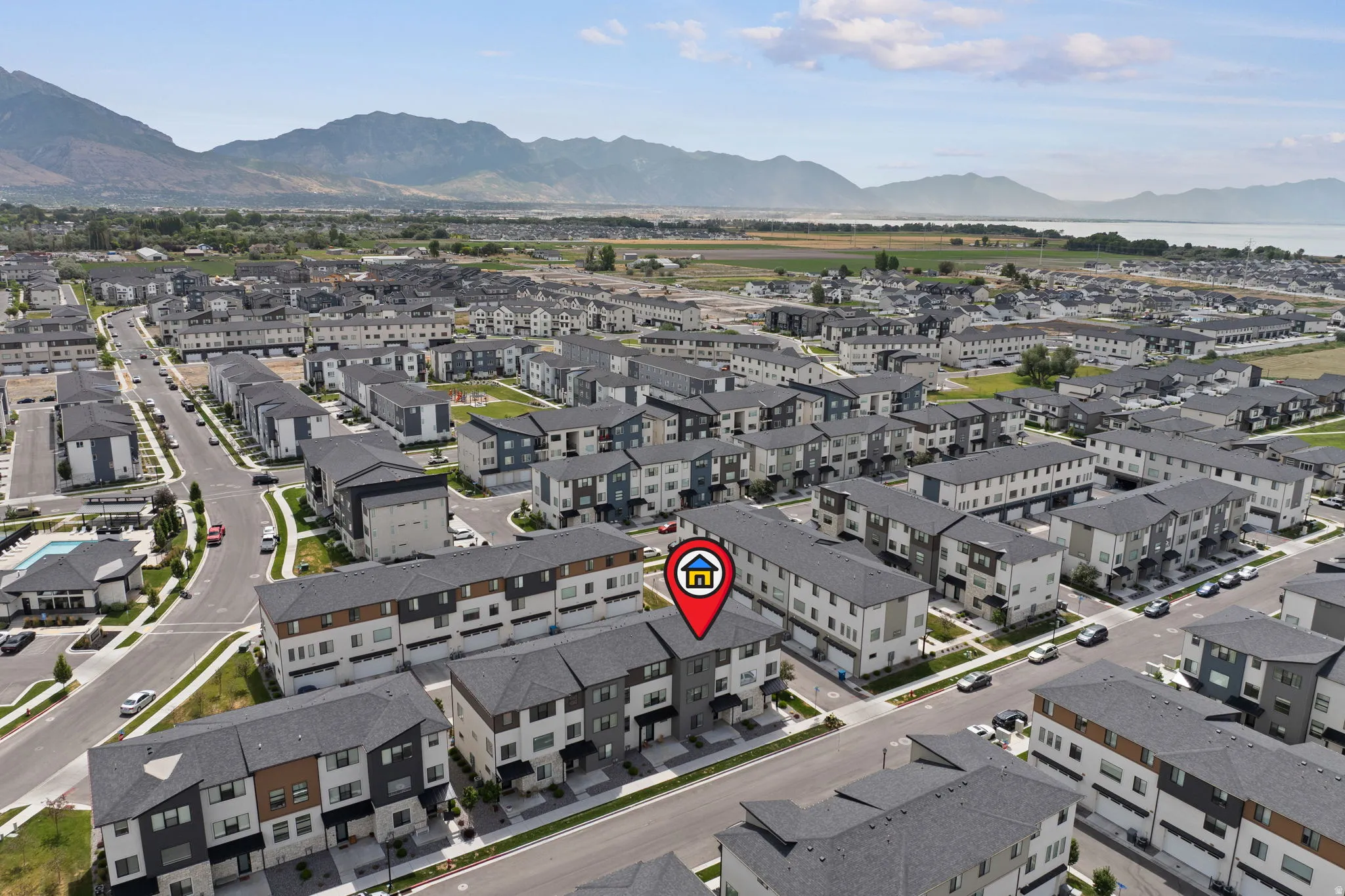 Aerial perspective showcasing a community of multi-story townhomes with mountain and water backdrops