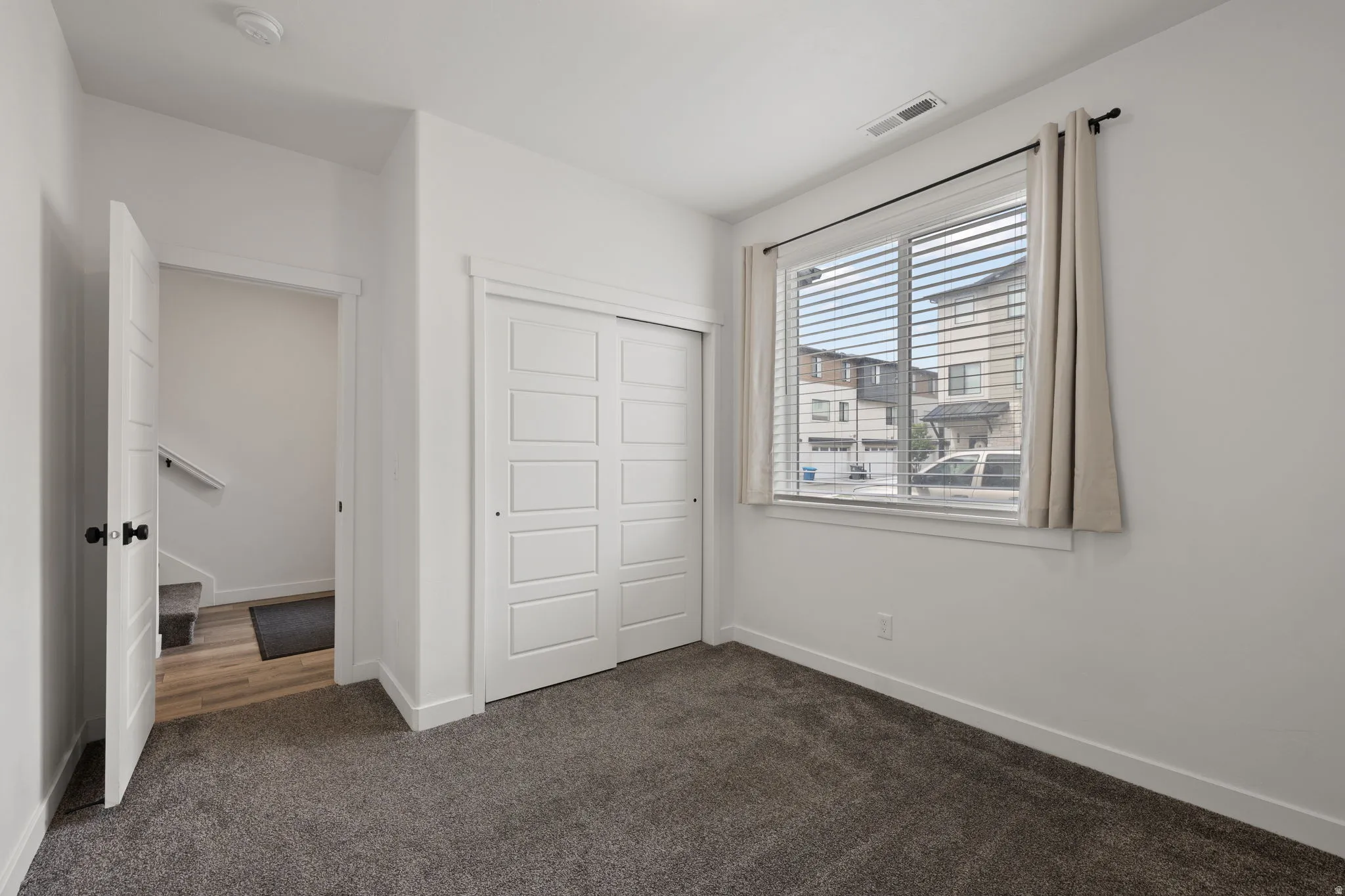 Comfortable room featuring dark gray carpet flooring and white walls