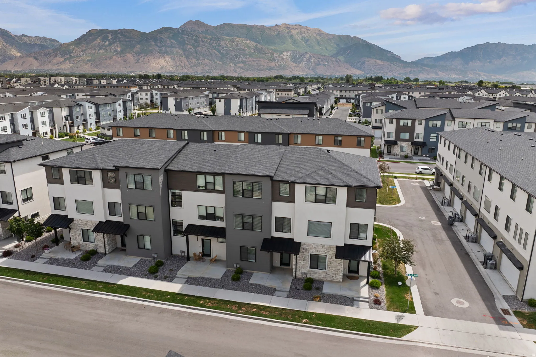 Contemporary townhome structures featuring multi-tone facades, stone accents, and dark pitched roofs
