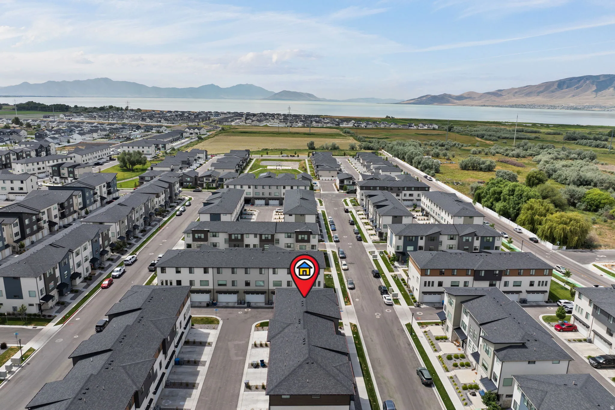 Aerial perspective showcasing a community of townhome-style residences with dark shingle roofs