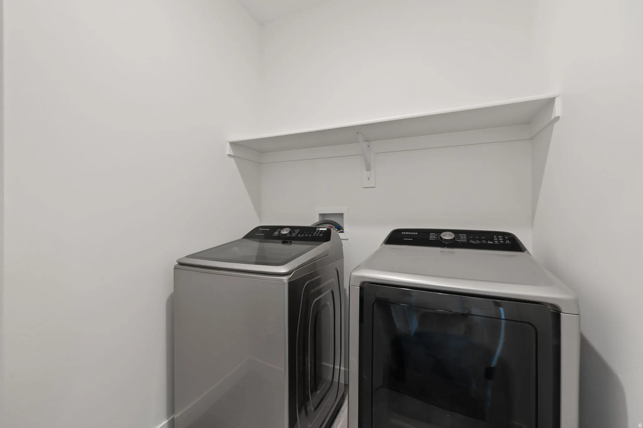Laundry area featuring a built-in white shelf