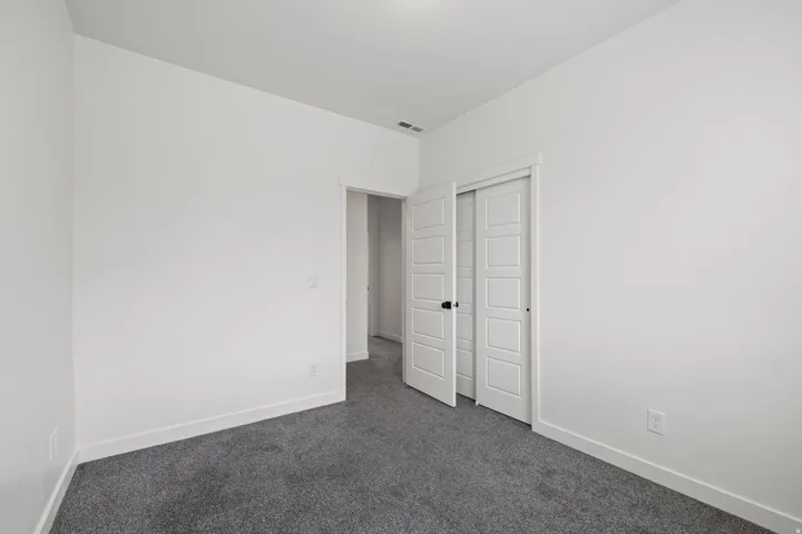 White painted interior with gray carpeting and white baseboards