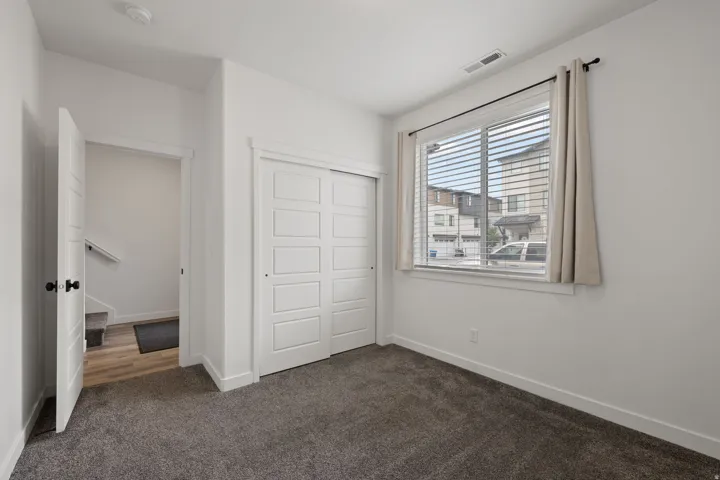 Comfortable room featuring dark gray carpet flooring and white walls