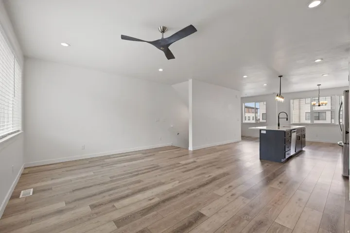 Open-concept living area featuring wood-finish flooring, recessed lighting, and a modern ceiling fan