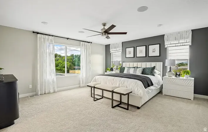 Generous room featuring plush neutral carpeting and a contemporary ceiling fan