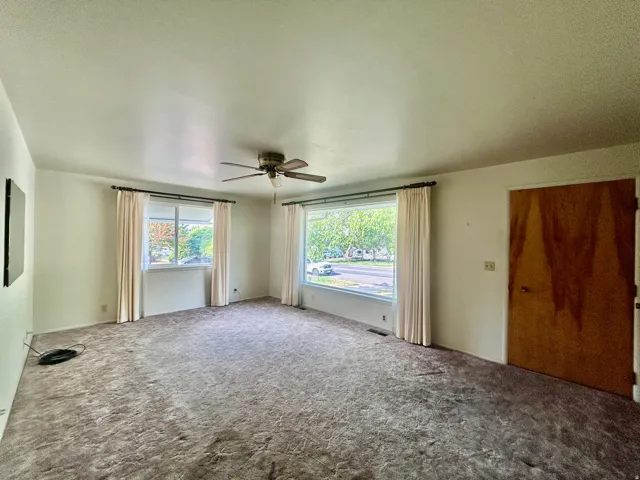 Spacious living room with two corner windows including a large front picture window