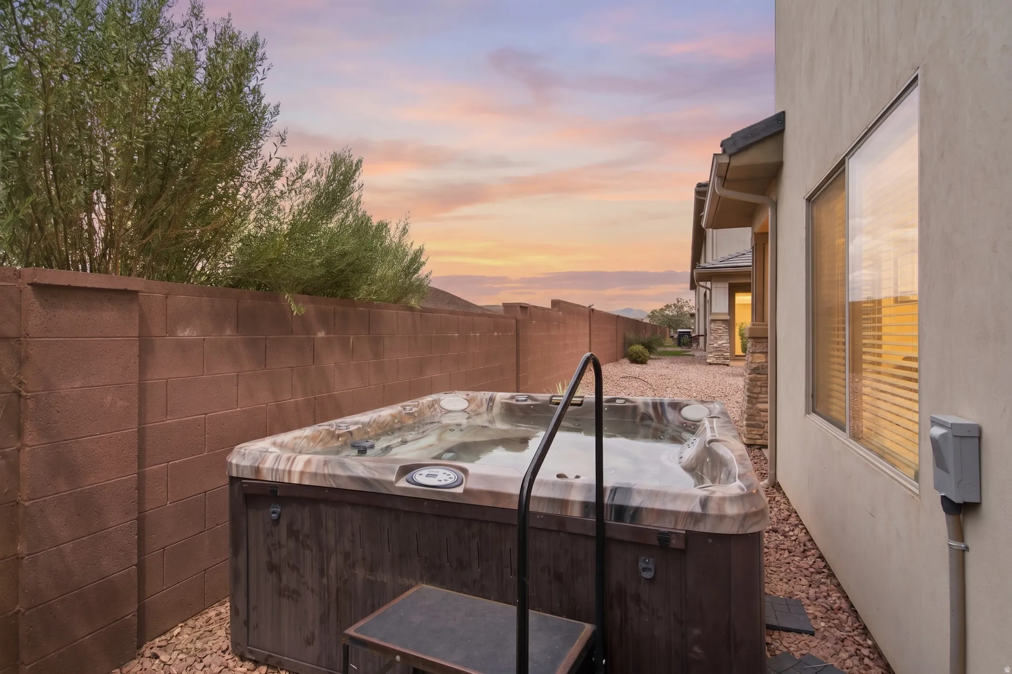 Outdoor spa featuring a wood-finish cabinet and integrated control panel