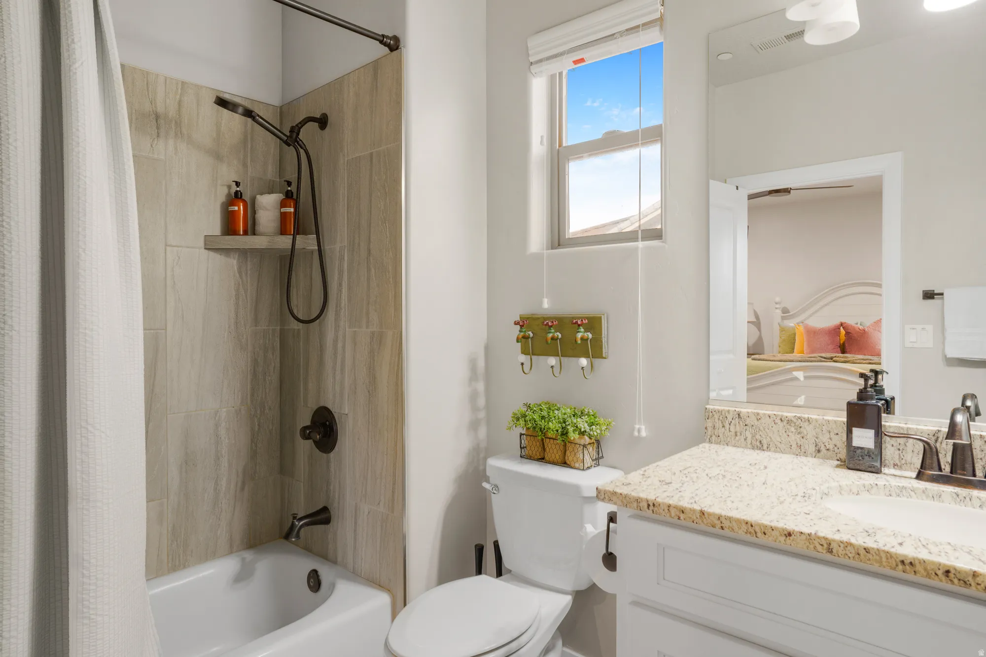 Bathroom featuring a bathtub/shower combination with tile surround and dark bronze fixtures