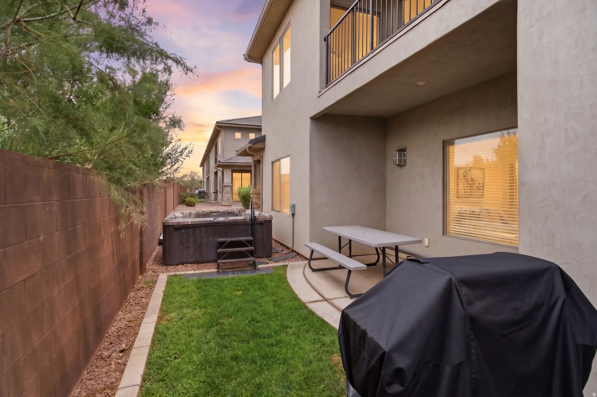 Private backyard with a built-in spa, concrete block perimeter wall, and a grass area