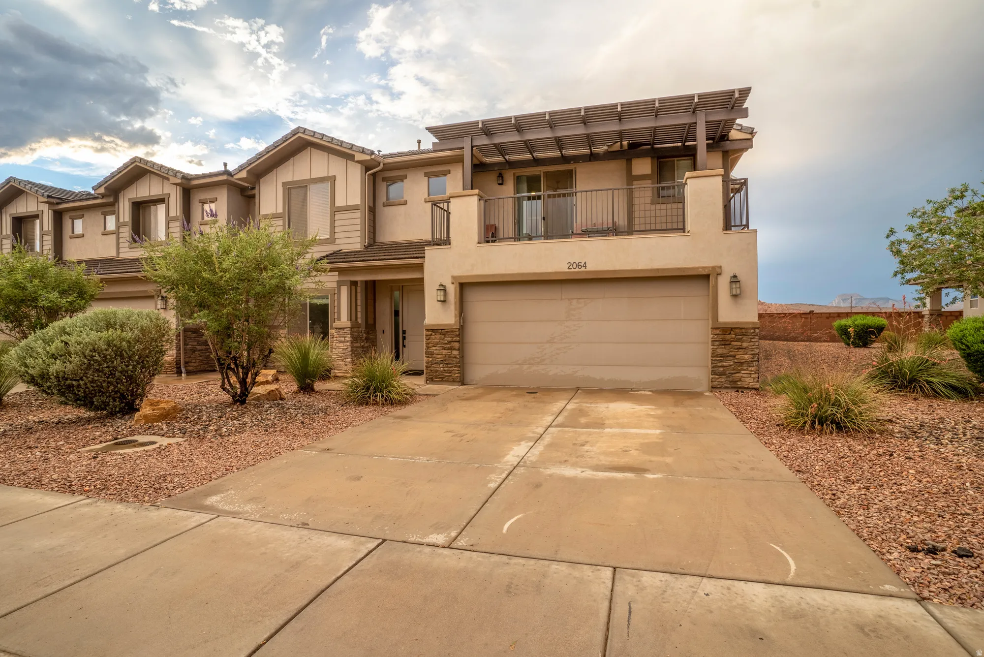 Contemporary stucco exterior with stone accents and an attached garage