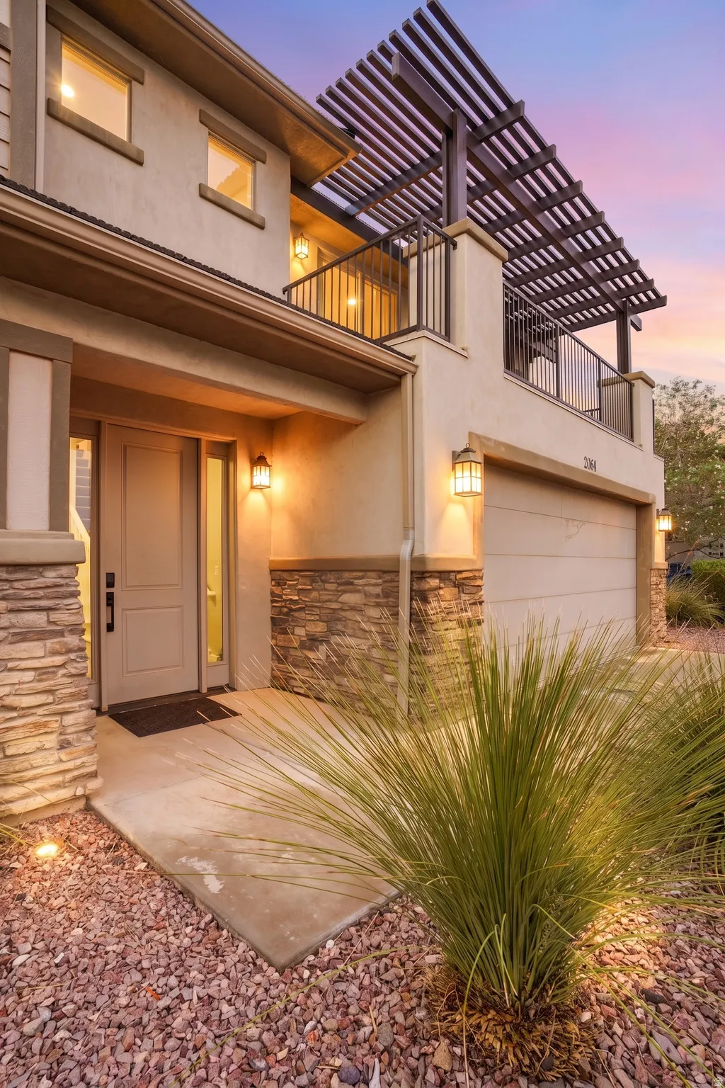 Stucco exterior with stone accents and an integrated garage