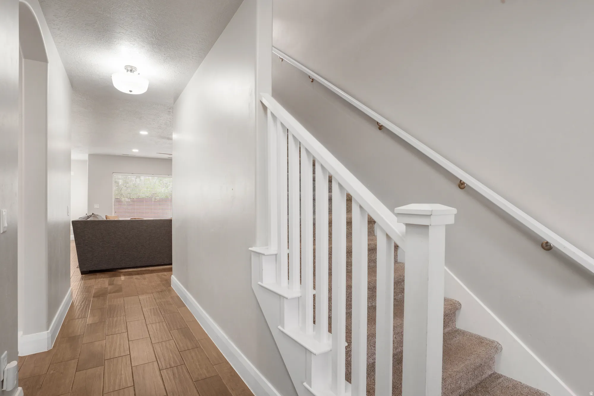 Staircase featuring white balusters and a carpeted tread